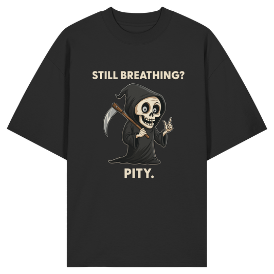 Black oversized shirt with cartoon grim reaper holding scythe and text "Still breathing? Pity." in beige letters