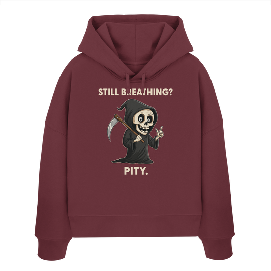 Womens organic boxcut hoodie with sarcastic grim reaper and "Still breathing? Pity." black humor design.